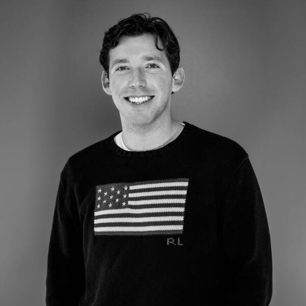 Chris Russo smiling pose on black and white background, American flag shirt