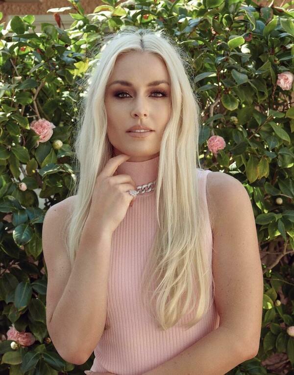 Lindsey Vonn profile picture blonde hair pink shirt in front of a bush with pink flowers