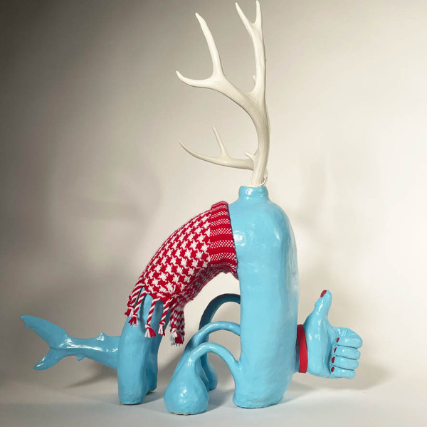 A blue sculpture with a thumbs up, red scarf, a dolphin tail